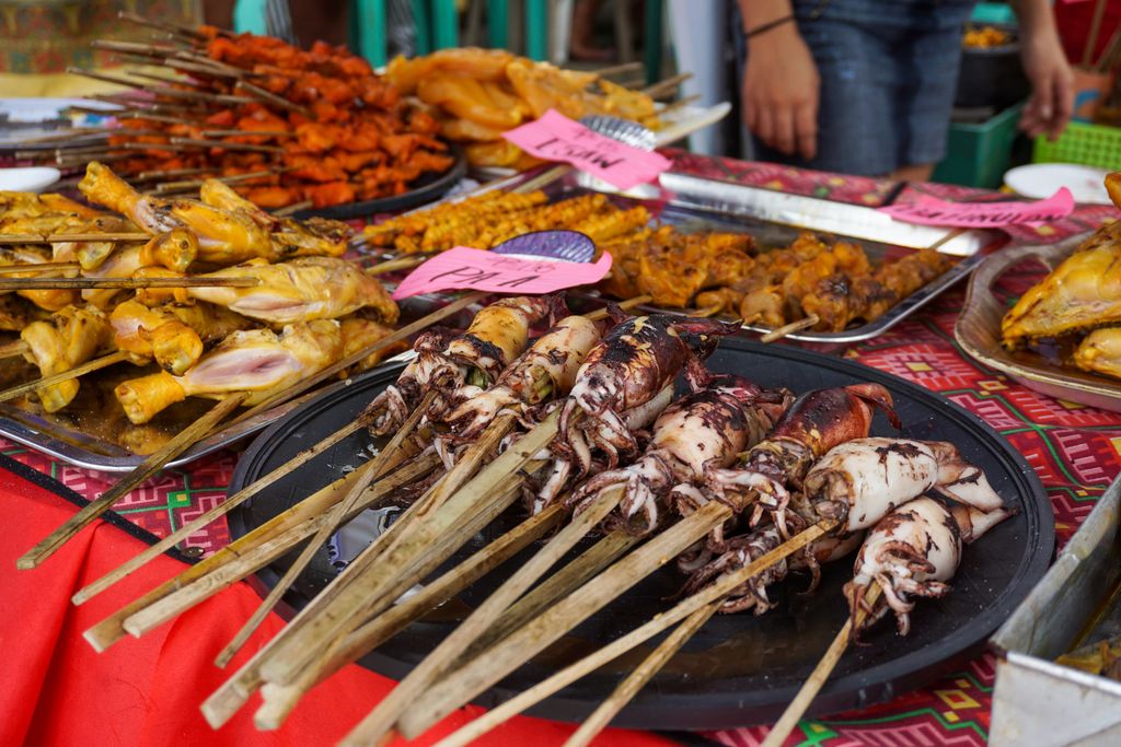 Colorful display of skewered seafood and meats at a traditional Filipino street food market in Iloilo City.